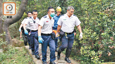 救護員與消防員合力將傷者抬落山。（曾志恒攝）