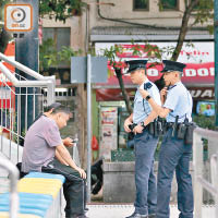 警員到擊壤路球場巡邏，查看身份證。（文健雄攝）