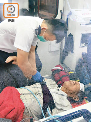 跑馬地<br>意外墮坑的印尼華僑額頭受傷，送院時面露痛苦神色。（吳建明攝）