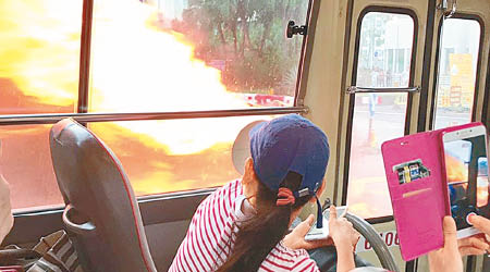 小巴女乘客見火勢猛烈，側着身躲避。（互聯網圖片）