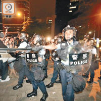 防暴警察持盾牌驅散示威者。