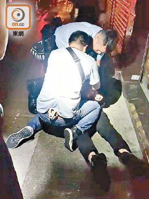 警員合力把男子按在地上。（讀者提供）