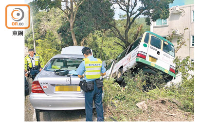 兩車剷上行人路，小巴衝落山坡，警員在場調查。（林耀康攝）