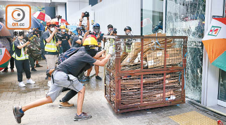 示威者用鐵籠車連番猛烈撞擊立法會玻璃幕牆。（黃偉邦攝）