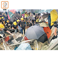 示威者衝擊大樓期間，雨傘、竹枝成為一攻一守武器。（高嘉業攝）