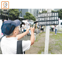 有參與集會市民在添馬公園掛上批評黎智英的紙牌。（袁志豪攝）
