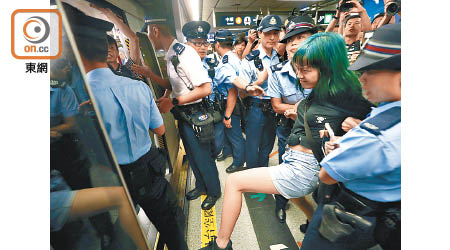 警方合力把阻礙車門關上的市民拉離港鐵列車。