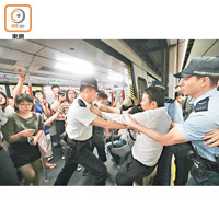 警方拉走參與不合作運動的人士，免阻礙列車關門。（何量鈞攝）