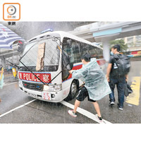 示威者拍打警車洩憤，車頭擋風玻璃前的防襲鐵網鬆脫。