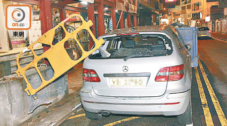 平治車尾擋風玻璃爆裂，一個黃色膠圍欄擱在上面。（楊日權攝）