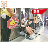 不合作運動成員在荔景站索性坐在列車與月台之間。（吳艷玲攝）