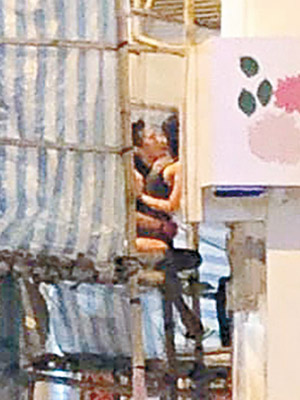 有情侶坐在棚架上熱吻。（互聯網圖片）