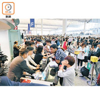 大批旅客湧到櫃位查詢航班最新情況。