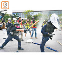 示威者用球棒毆打警察。
