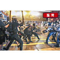 示威者持長棍及木條追打防暴警員。（美聯社圖片）