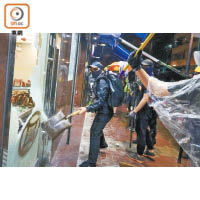示威者在荃灣用鐵剷破壞麻雀館大門。