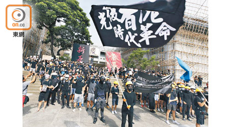 黑衣學生戴上口罩，高舉「光復香港，時代革命」的旗幟。（李志湧攝）