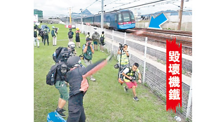 示威者向機鐵路軌掟石（箭嘴示）。（電視畫面）