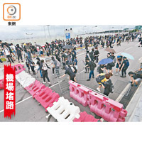示威者在機場公路搬水馬砌路障。（胡家豪攝）