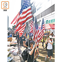 遊行人士沿路高舉美國旗。（何天成攝）