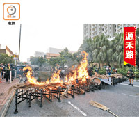 示威者疊高鐵馬及雜物，再堆放乾葉紙皮燃燒成多個烈火路障。（陳德賢攝）