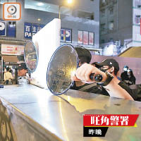 示威者用鏡反射警方的強光。