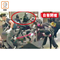 示威者用鐵通打向警員右手，警員右手開槍（紅圈示）。