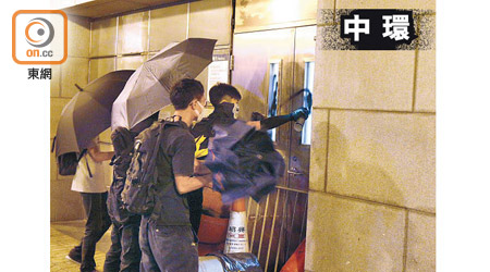 示威者在機鐵站門外噴漆。（何天成攝）