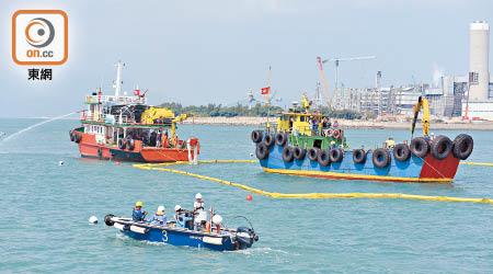 油污清理隊伍架圍油欄把模擬運油船包圍，並用圍油欄在模擬運油船附近架設海上屏障。