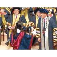 女哲學博士畢業生到滕錦光前欲與他握手。（無綫電視畫面）