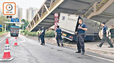 解款車左車身擱在花槽上，解款員持槍把守。