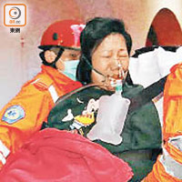 一名女住客送院時需戴上氧氣罩協助呼吸。