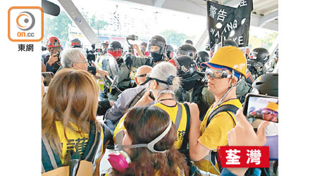 防暴警察在荃灣天橋舉旗警告聚集人群散離，現場有多名長者。（溫國佳攝）