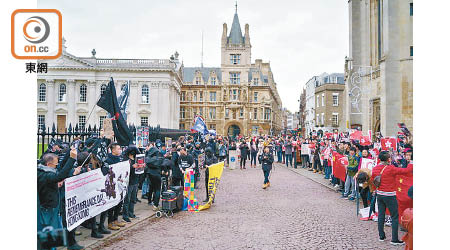 逾百名黑衣人在劍橋大學外遊行。