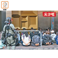 被捕示威者坐在路上等候押走。（蕭毅攝）