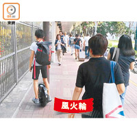 有青年在行人路上以風火輪代步。