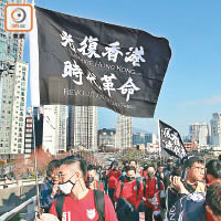 有香港球迷舉起印有「光復香港、時代革命」旗幟。（黃雋謙攝）