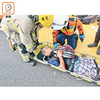 救援人員把一名男子抬上擔架床送院。