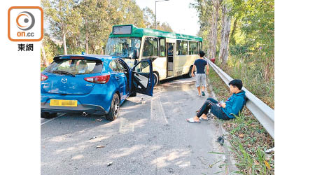 小巴與私家車相撞，有傷者坐在路邊待援。（胡德威攝）