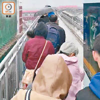 乘客冒雨沿車軌離開。