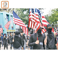 黑衣人手持美國旗沿途揮舞。（黃仲民攝）