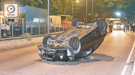 私家車四輪朝天橫亘路中。（梁穎福攝）