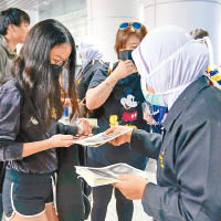 馬來西亞：馬來西亞向旅客派發防疫小冊子。（美聯社圖片）
