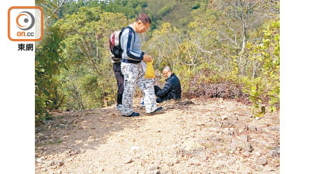 事主受傷坐在地上待援，有其他行山人士上前協助。