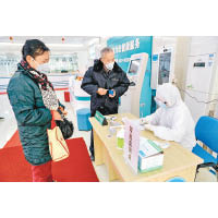 武漢的社區醫務工作者對就診市民進行登記。（中新社圖片）