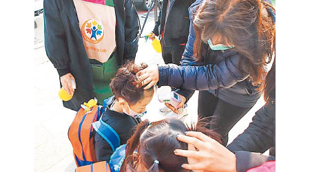 台灣高雄教師為幼兒園學童量體溫。