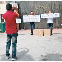 華裔人士在總領事館門外展示標語。