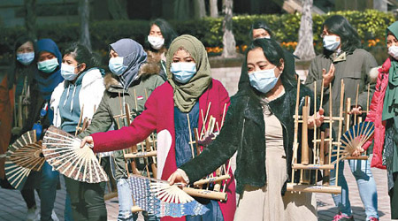 在香港工作的印尼女傭外出時戴上口罩。（美聯社圖片）