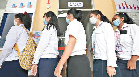 柬埔寨<br>柬埔寨首都金邊的學生排隊消毒雙手。（美聯社圖片）