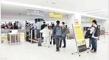 日本政府昨宣布暫停香港及澳門旅客免簽證。圖為旅客入境東京時接受測溫。
